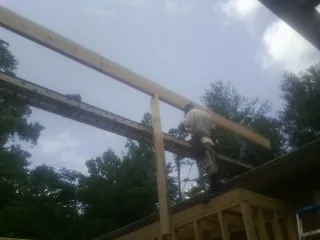 Carpenter setting a ridge beam over a new addition frame — Ice Dam Removal by Roofing Brothers in Rowley