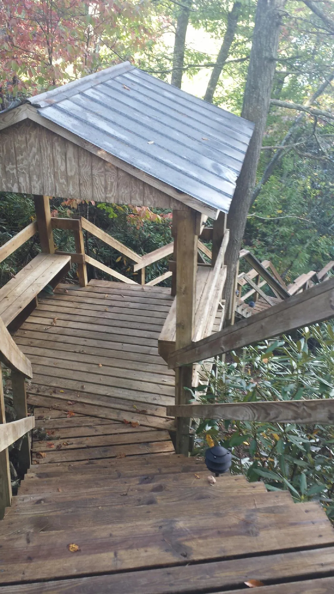 Metal roofed shelter over wooden steps on a wooded walkway — Skylight Repair & Installation work by our crew in Rowley