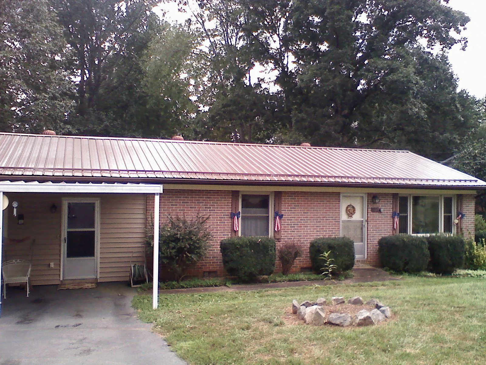 Bronze metal roof and carport on a brick ranch home — Roof Repair work by our crew in Rowley